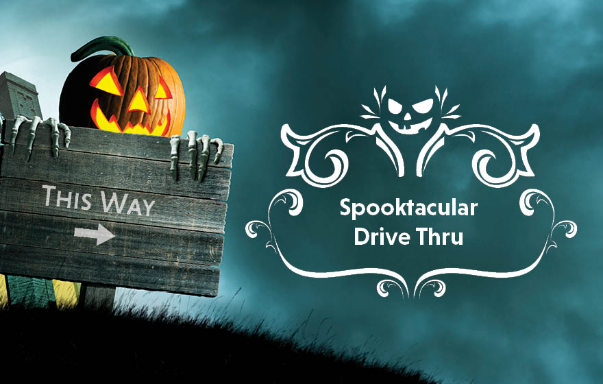 A Halloween pumpkin and a sign that says This Way to Spooktacular Drive Thru