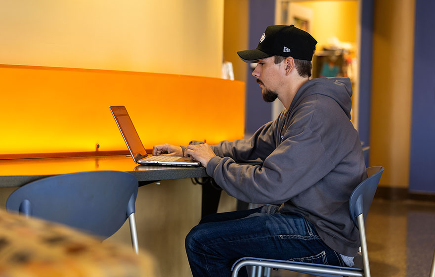 Student working on financial aid on his laptop