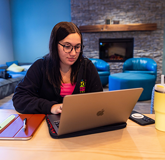 Student sitting at desk working on laptop