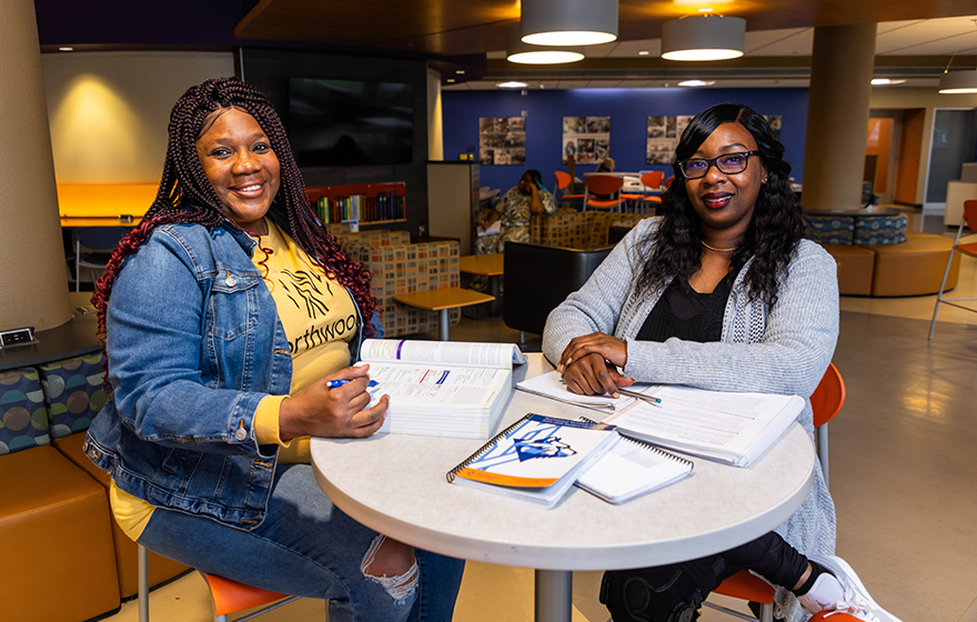 Students smiling at camera while going over class assignments