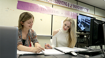 Two students looking at a notebook