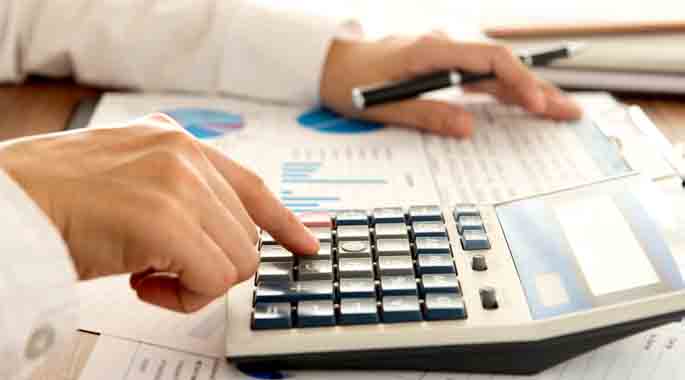 Close up of a hand using a calculator