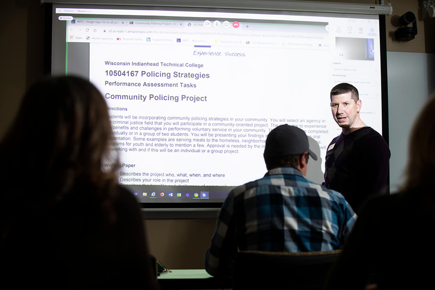 An instructor lecturing in front of a classroom