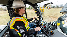 A utility construction student using a heavy machine