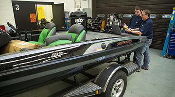 Marine repair students learning with a hands-on lesson in the marine lab