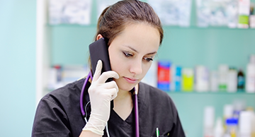 A veterinary technician on the phone in a vet's office