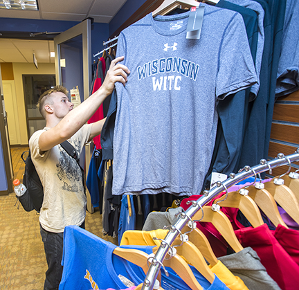 A student browsing through WITC t-shirts