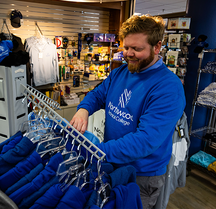 A student browsing through Northwood Tech t-shirts