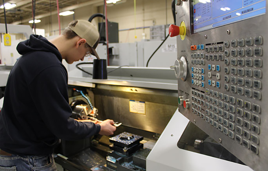 Student working on machine in classroom