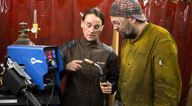 An instructor showing a student how to use the tools of the trade