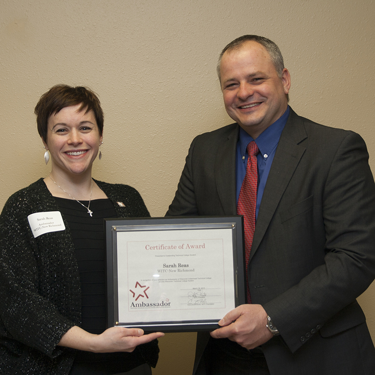 WITC President John Will presenting a female student with a student ambassador award.