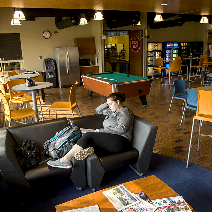 Picture of a student relaxed on a couch in the WITC-Ashland commons area