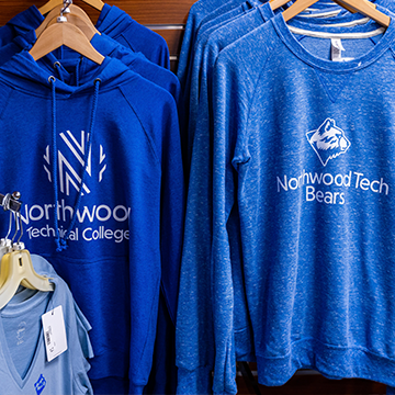 Blue Northwood Tech shirts hanging in the bookstore