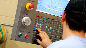 A student operating a CNC machine