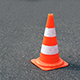 Orange cone sitting on tar