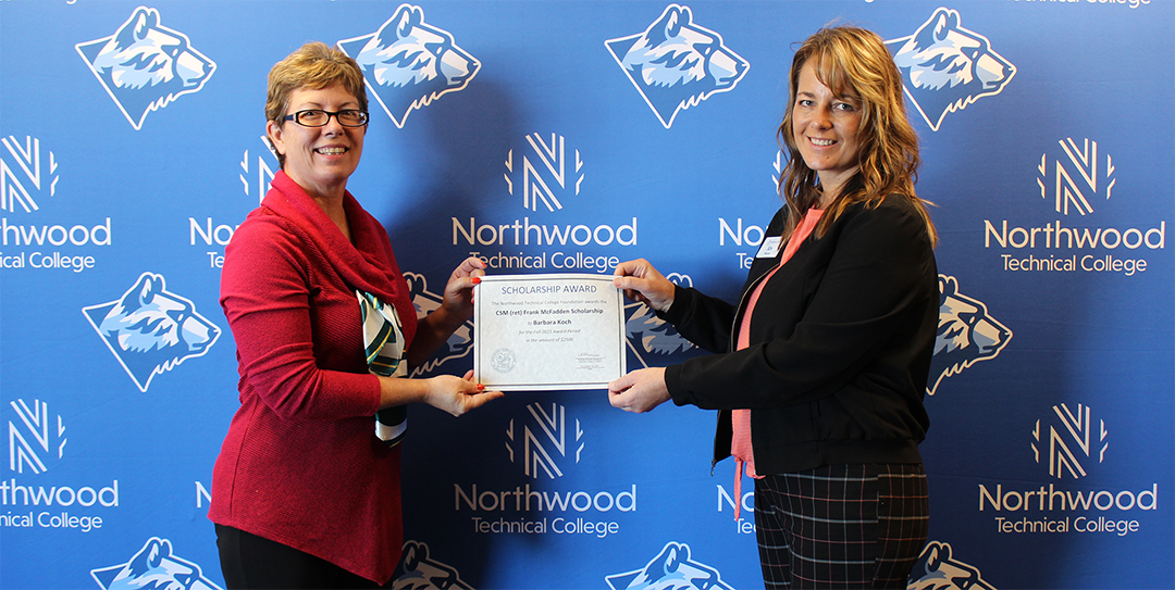 A student holding their scholarship award