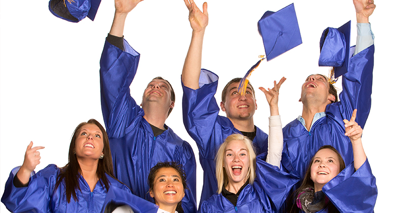 Students throwing graduation caps into the air looking happy and excited