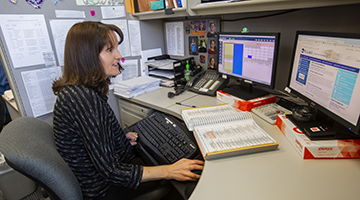 A medical administrative professional looking at a computer