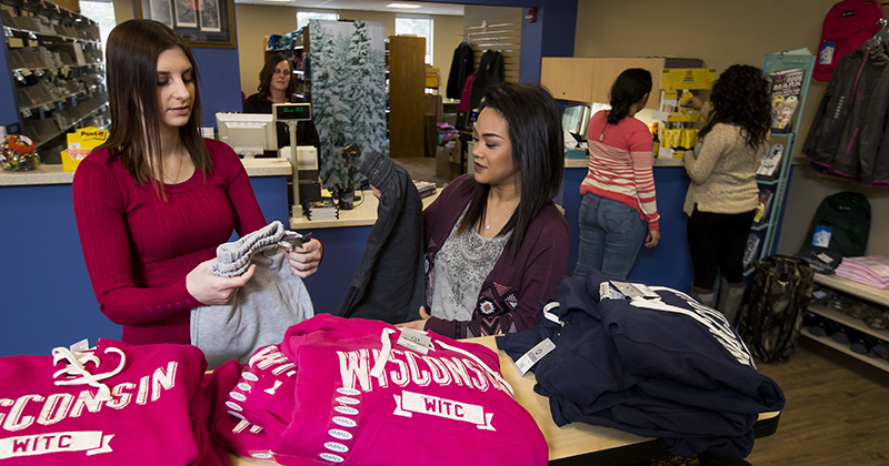 Two students in the book store Two female students in the book store sift through WITC shirts and sweatshirts