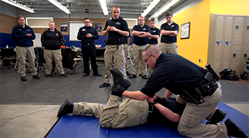 Students practicing restraining a criminal