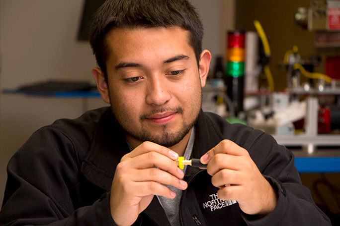 A student looking at a part