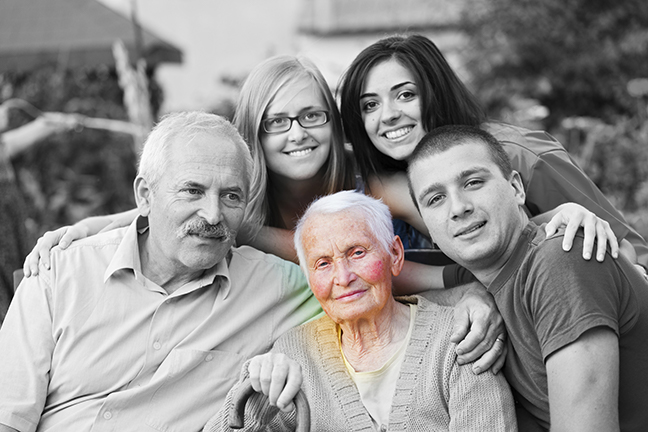 A family surrounding an aging adult who is a close relative