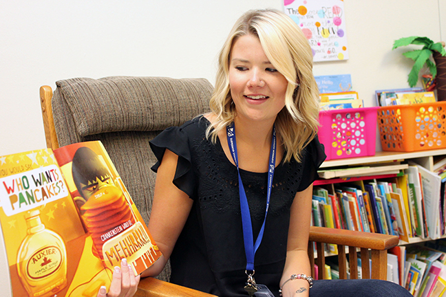 An early childhood educator reading a children's book aloud