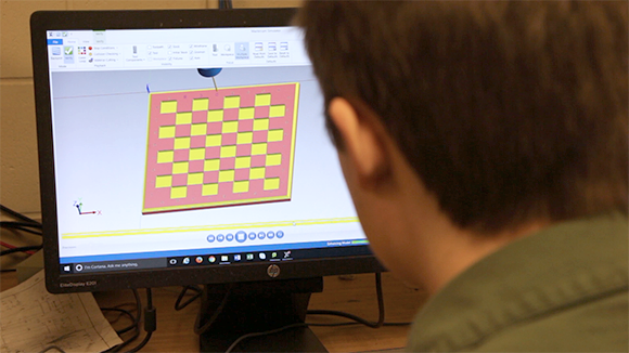 A machine tool operation student working on a computer