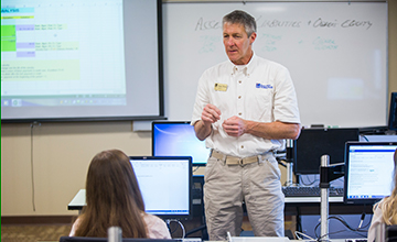 An instructor at the front of a classroom