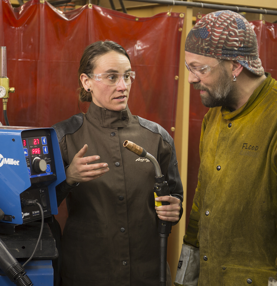Female welding instructor works with a male student Female welding instructor works with a male student