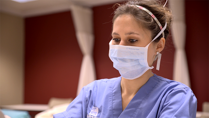 A nursing student wearing a surgical face mask 
