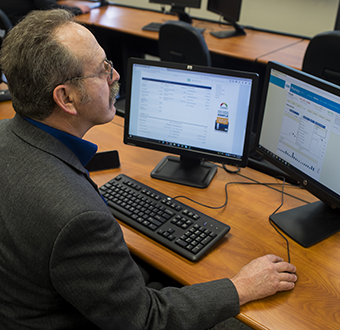 Man works at his desktop with two screens