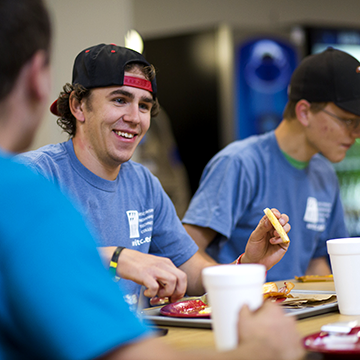 Student sitting in a group, eating and laughing.