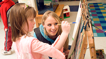An early childhood education student doing art with a young child