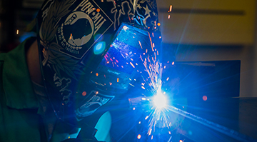 A student welding and sparks flying