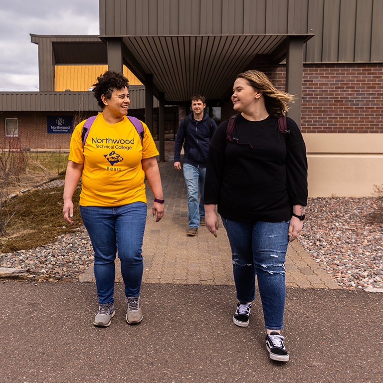 Three students, a male and two females, walking outside the Ashland campus