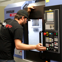 A student is working at a machine, watching for the end result