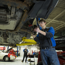 A student working under a vehicle