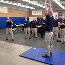 Criminal Justice student pointing a gun, hands up