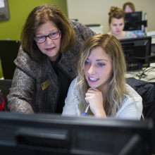 Student working on computer with Instructor help