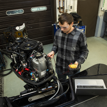 A student working on an outboard motor