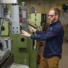 A student works on a big green machine