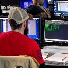 Student in red shirt using drafting software on computer