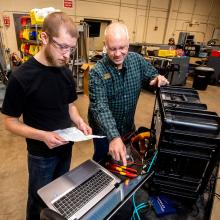 Automation student receiving instructor guidance with a machine