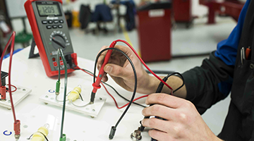 Student in the automotive lab working with a digital multimeter