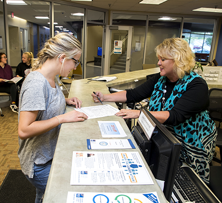 A WITC student looking over a document with a member of WITC's support staff