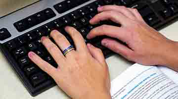 Hands typing on a keyboard