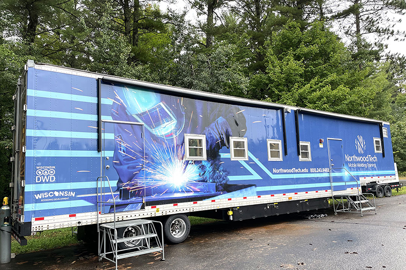External view of 53 foot welding lab trailer covered in welding graphics