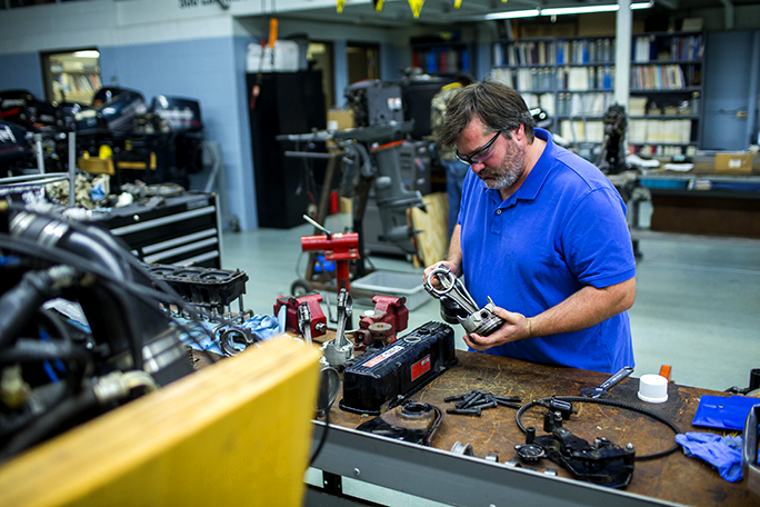 Marine repair student working with tools in the marine repair lab