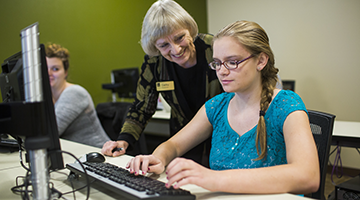An instructor helping a student on the computer